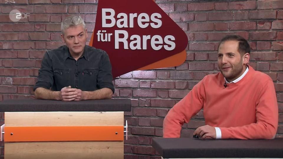 "Ich habe den Bausatz gekauft 1976", stellte Jürgen sein Modell im Händlerraum vor. "Und dann haben Sie sich gedacht, Sie modellieren uns noch den lieben Horst nach?", freute sich Julian Schmitz-Avila (rechts) über das Figürchen. (Bild: ZDF)