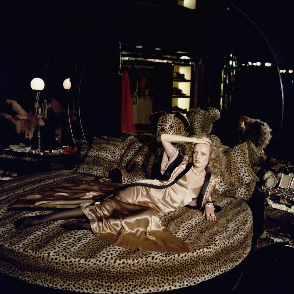 <p>English model Twiggy poses on a circular bed with leopard print bedding in a satin evening gown in 1971. </p>