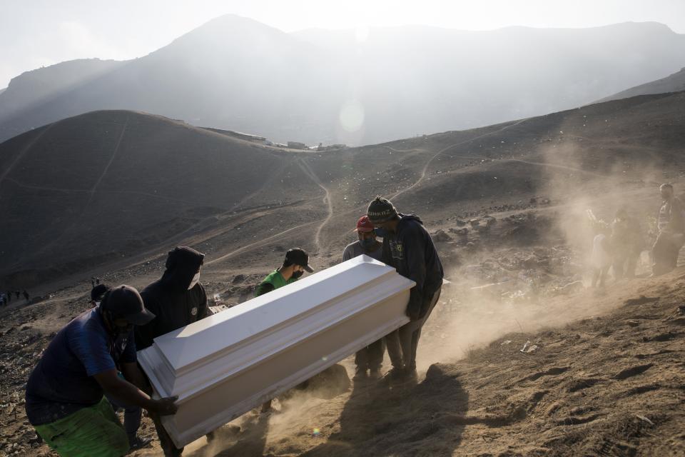 Cemetery workers carry the coffin of Jorge Luis Collahua, during his burial in the section of Nueva Esperanza cemetery reserved for COVID-19 cases, in the outskirts of Lima, Peru, Monday, June 1, 2020. Collahua's family did not want to talk about whether he died of the coronavirus. (AP Photo/Rodrigo Abd)