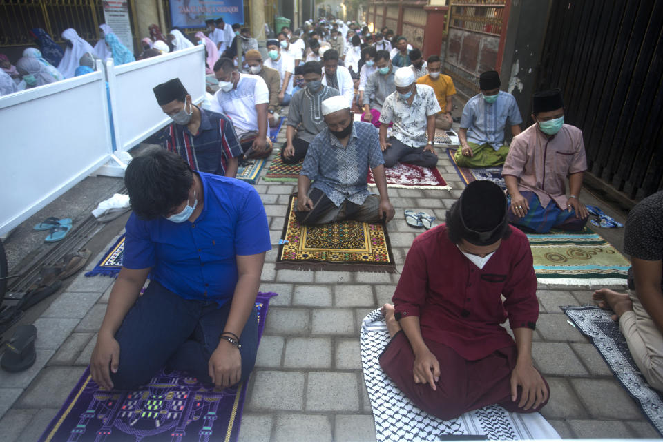 Muslims wearing face masks offer the Eid al-Fitr prayer with a distance setting in Bali, Indonesia on Thursday, May 13, 2021. Indonesian Muslims perform Eid al-Fitr prayer that marks the end of the holy fasting month of Ramadan. (AP Photo/Firdia Lisnawati)