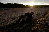 Recruit Damian Krasnodebski, 27, an architect, crawls with an ammunition box during his 16-day basic training for Poland's Territorial Defence Forces, near a shooting range near Siedlce, Poland, December 8, 2017. REUTERS/Kacper Pempel/Files