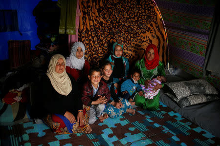 Displaced Iraqi Hanyeih Ibraheem, 45, poses for a photograph in a tent with her family at Hammam al-Alil camp south of Mosul, Iraq, March 29, 2017. Ibraheem, who lost her husband in the Iran-Iraq war in the 80's, says she and her family arrived two weeks ago. They left West Mosul at daybreak and reached the camp after 48 hours. Her sons have left the tent to try and look for work. REUTERS/Suhaib Salem