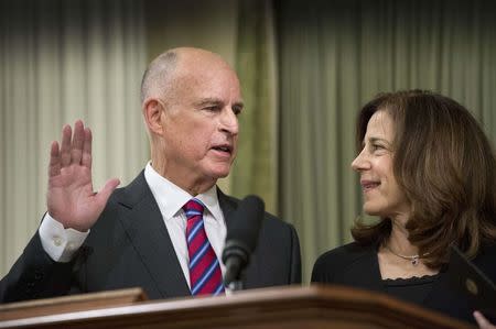 California Governor Jerry Brown (L) takes a historic fourth oath of office as governor with First Lady of California Anne Gust Brown at his inauguration at the State Capitol in Sacramento, January 5, 2015. REUTERS/Hector Amezcua/Pool