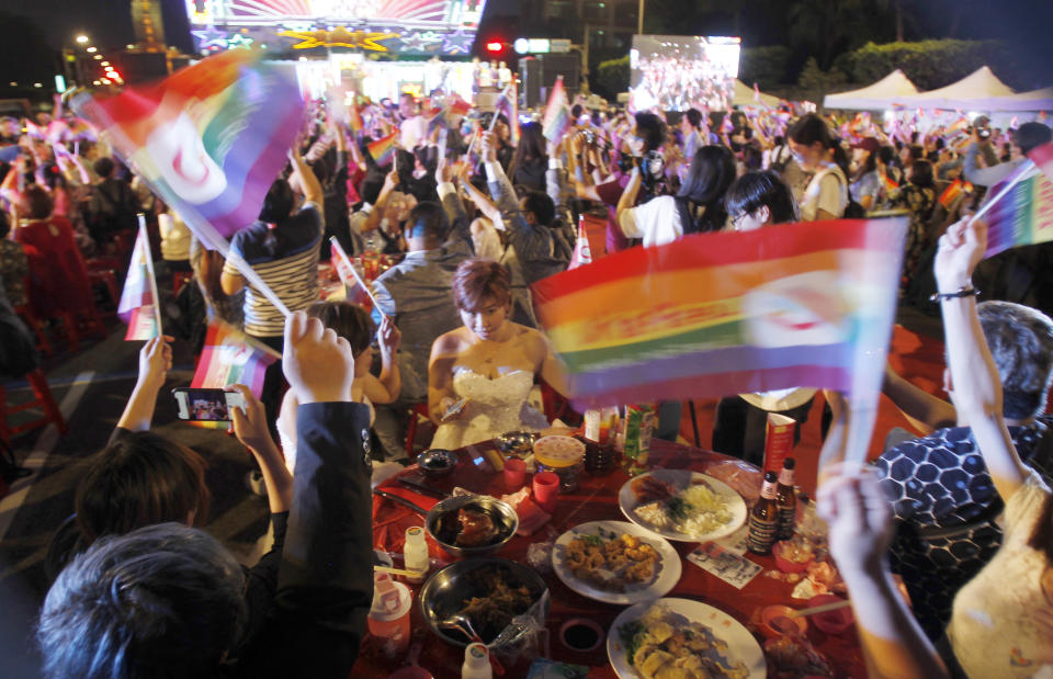 Taiwanese same-sex couples cheer with supporters at their wedding party in Taipei, Taiwan, Saturday, May 25, 2019. Taiwan became the first place in Asia to allow same-sex marriage last week. Hundreds of same-sex couples in Taiwan rushed to get married Friday, the first day a landmark decision that legalized same-sex marriage took effect. (AP Photo/Chiang Ying-ying)
