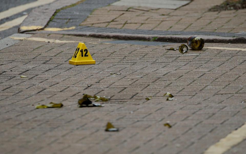 A broken glass is seen near an evidence marker after reported stabbings in Birmingham - REUTERS/Phil Noble