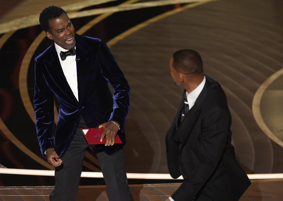 FILE - Presenter Chris Rock, left, reacts after being hit on stage by Will Smith while presenting the award for best documentary feature at the Oscars on Sunday, March 27, 2022, at the Dolby Theatre in Los Angeles. Rock's comment afterward, "Will Smith just smacked the s--- out of me," made the top five of a Yale Law School librarian's list of the most notable quotations of 2022. (AP Photo/Chris Pizzello)