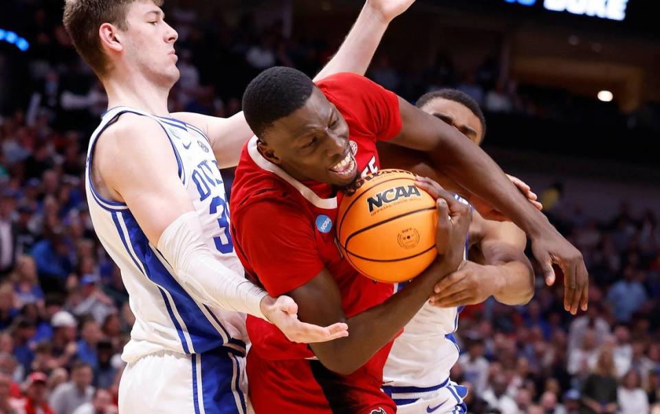 N.C. State’s Mohamed Diarra (23) pulls in the rebound from Duke’s Kyle Filipowski (30) and Jaylen Blakes (2) during the first half of N.C. State’s game against Duke in their NCAA Tournament Elite Eight matchup at the American Airlines Center in Dallas, Texas, Sunday, March 31, 2024.