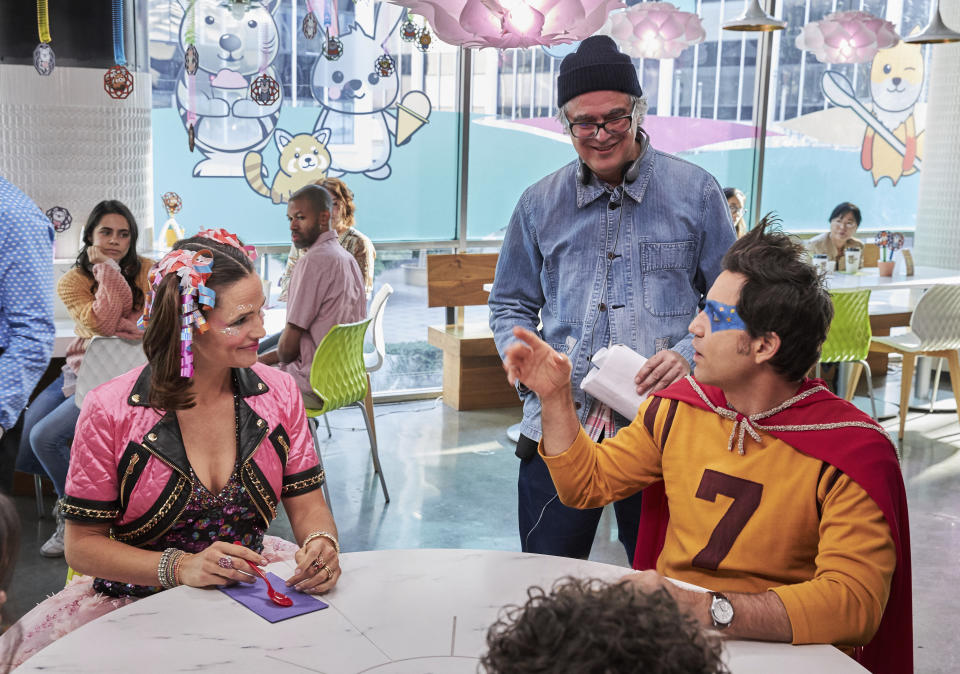 Director Miguel Arteta, standing center, appears on the set of his film "Yes Day" with actors Jennifer Garner, seated left, and Edgar Ramirez. (John P. Johnson/Netflix via AP)