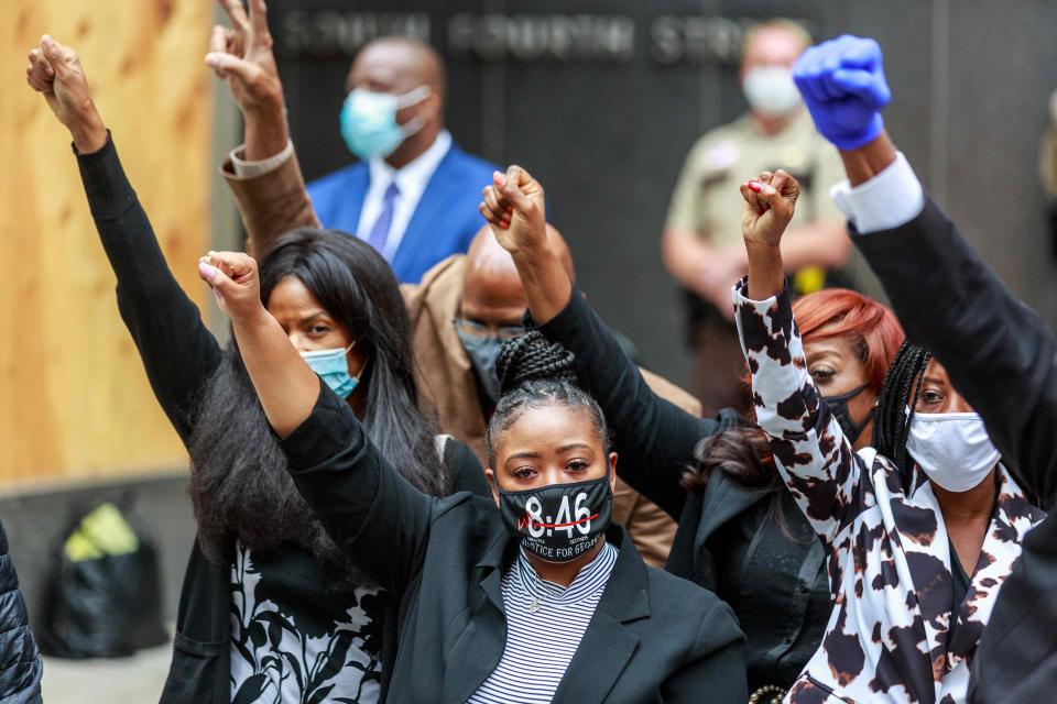 George Floyd's family raise their hands at a press conference outside the family justice center in Minneapolis on Sept. 11 after a court hearing.