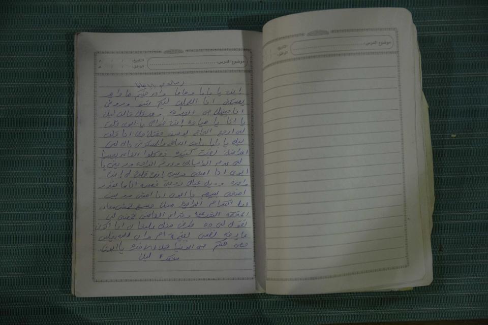 This Jan. 12, 2020 photo shows the diary of Mayada, a 22-year-old tea vendor who was among dozens of women raped by Sudanese security forces over the course of a few hours during the crushing of a protest camp on June 3, 2019, in Khartoum, Sudan. Mayada became pregnant with twins and gave birth to a daughter in March. The other twin, a boy, died. The poem in Arabic is addressed to her mother and father. (AP Photo/Nariman El-Mofty)