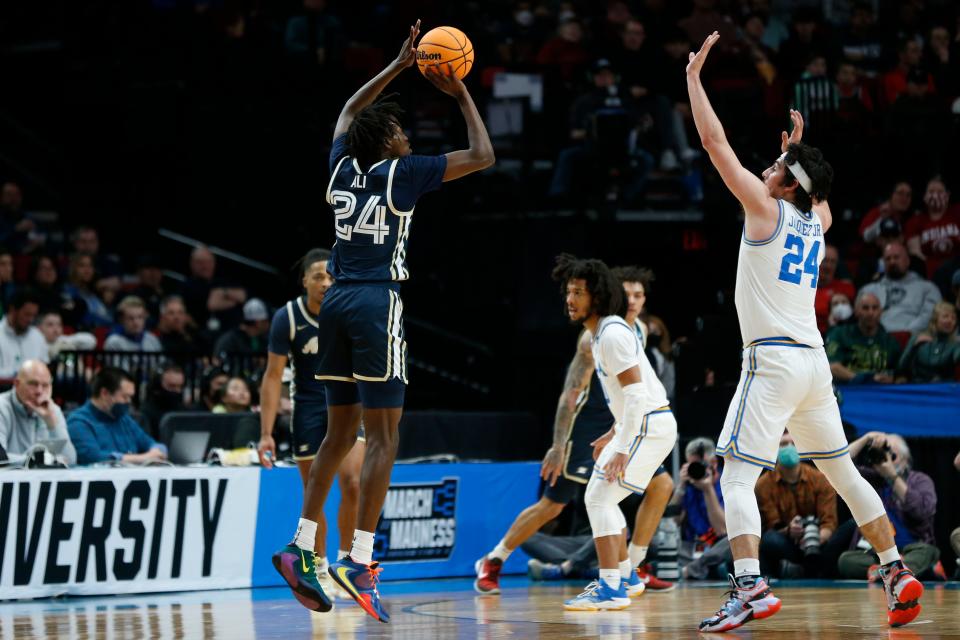 Akron forward Ali Ali, left, shoots over UCLA guard Jaime Jaquez Jr., right, during a first-round NCAA college basketball tournament game March 17, 2022, in Portland, Ore.