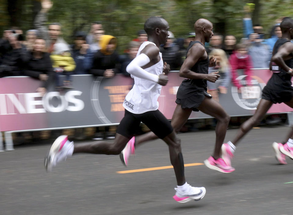 In this Oct. 12, 2019 photo, marathon runner Eliud Kipchoge from Kenya, white vest, wearing Nike AlphaFly prototype running shoe, and his pacemaking team, wearing pink Nike Vaporfly shoes, run during the INEOS 1:59 Challenge attempt to run a sub two-hour marathon in Vienna, Austria. Nike has a new racing shoe; The Air Zoom Alphafly Next%, which was unveiled at a flashy fashion show in New York on Wednesday night, Feb. 5, 2020. Kipchoge wore a prototype of the shoe when he ran the world's first sub-2-hour marathon in an unofficial race in October. (AP Photo/Ronald Zak, File)