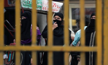 Veiled Muslim women wait for public transport in the old quarters of Delhi, May 1, 2019. REUTERS/Adnan Abidi