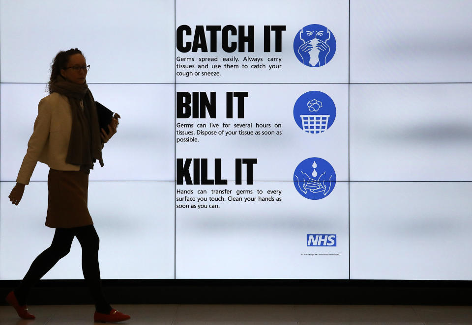 An NHS catch it, bin it, kill it sign on TV screens in the entrance to the QEII Centre in London.