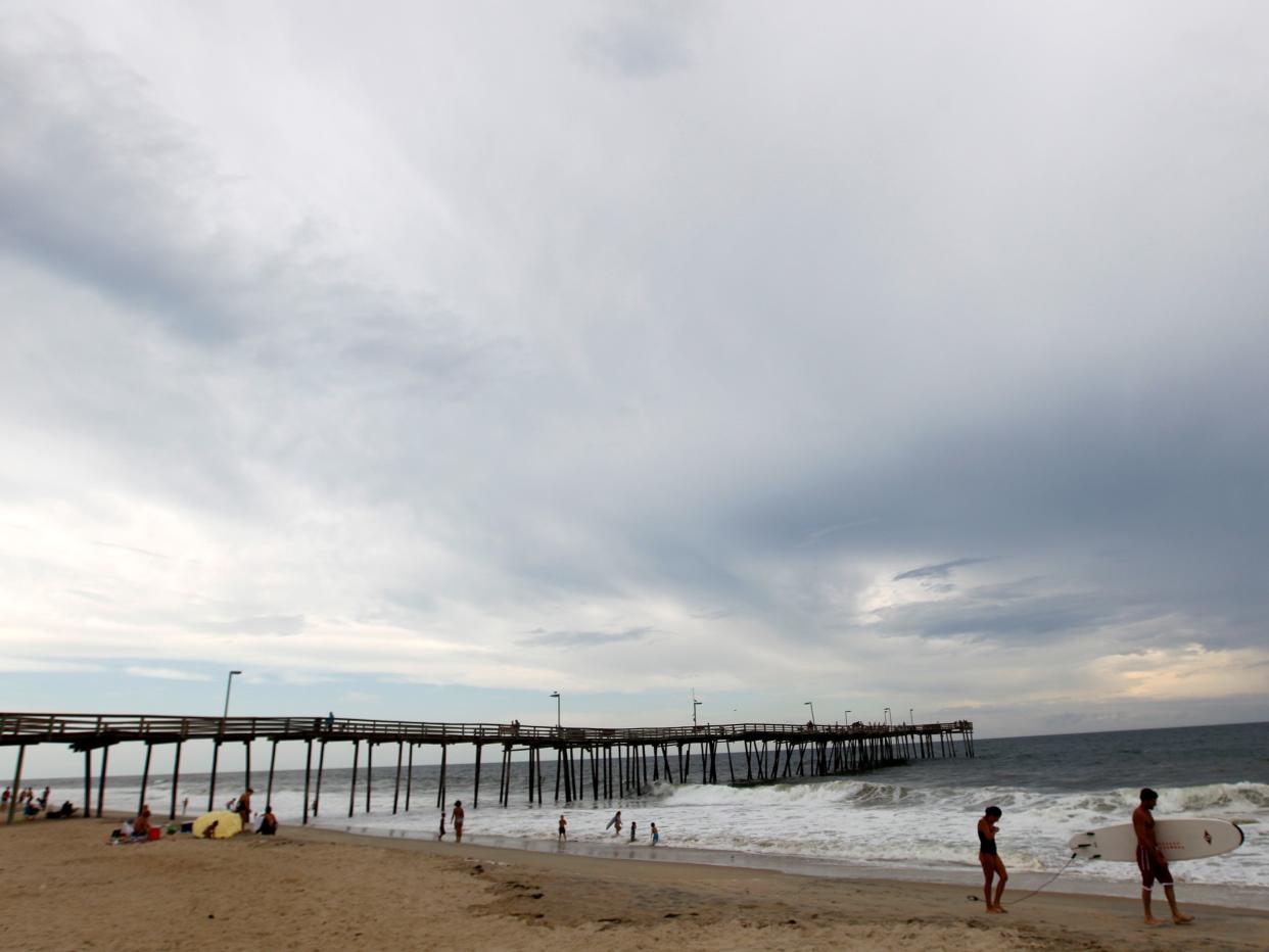 In this Aug. 24, 2011 photo, people play at the beach at Cape Hatteras National Seashore in Avon, N.C.