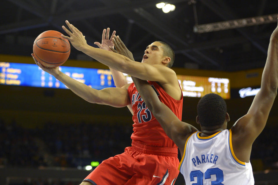 Arizona guard Nick Johnson, left, shoots as UCLA center Tony Parker defends during the first half of an NCAA college basketball game on Thursday, Jan. 9, 2014, in Los Angeles. (AP Photo/Mark J. Terrill)