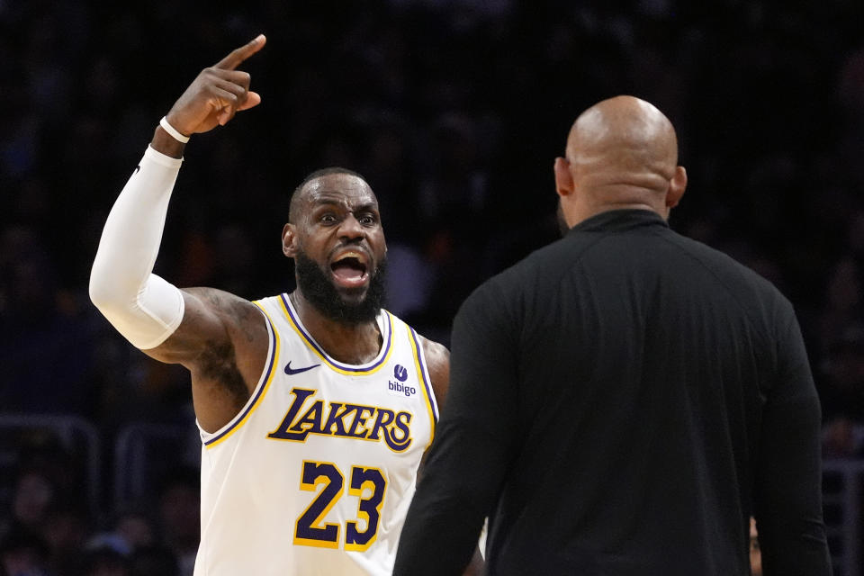 Los Angeles Lakers forward LeBron James, left, asks head coach Darvin Ham for a replay review after he was called for a foul during the second half in Game 4 of an NBA basketball first-round playoff series Saturday, April 27, 2024, in Los Angeles. (AP Photo/Mark J. Terrill)