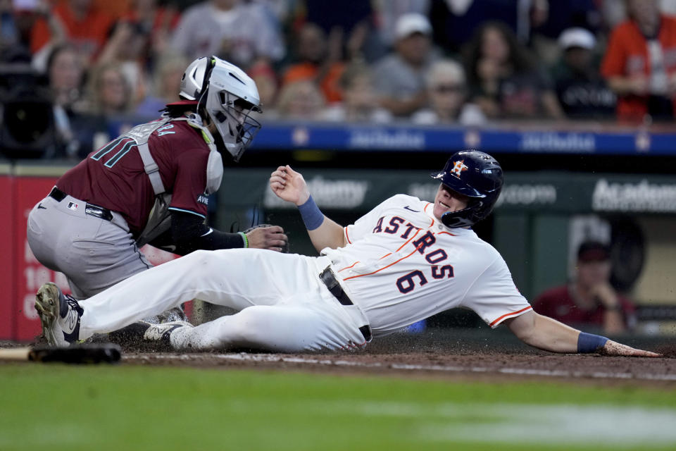 Houston Astros' Jake Meyers (6) slides past Arizona Diamondbacks catcher Jose Herrera to score on Chas McCormick's 2-run single during the fourth inning of a baseball game, Saturday, Sept. 7, 2024, in Houston. (AP Photo/Eric Christian Smith)