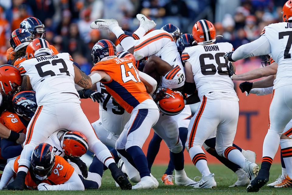 Browns running back Kareem Hunt is upended over Broncos linebacker Josey Jewell (47) as guard Michael Dunn (68) and center Nick Harris (53) block in the second quarter, Nov. 26, 2023, in Denver.