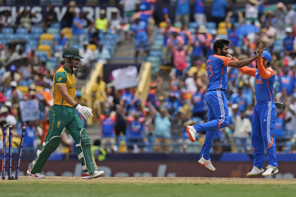 South Africa's Reeza Hendricks, left, is bowled out by India's Jasprit Bumrah, centre, during the ICC Men's T20 World Cup final cricket match between India and South Africa at Kensington Oval in Bridgetown, Barbados, Saturday, June 29, 2024. (AP Photo/Ramon Espinosa)