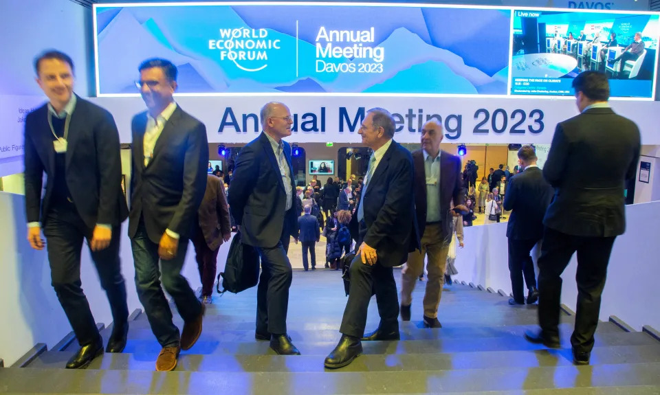 Participantes del Foro Económico Mundial (FEM) 2023 caminan en una sala del Centro de Congresos de Davos, en el centro turístico alpino de Davos, Suiza, el 18 de enero de 2023. Foto: REUTERS/Arnd Wiegmann