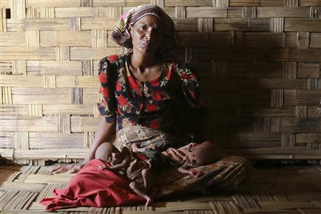 Displaced Rohingya woman Norbagoun carries her severely malnourished 25-day-old twins in her lap in their house at the Dar Paing camp for internally displaced people in Sittwe, Rakhine state, April 24, 2014. REUTERS/Minzayar