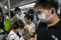 Commuters ride on a subway train during the morning rush hour in the central business district in Beijing, Tuesday, Aug. 9, 2022. China's 11 million university graduates are struggling in a bleak job market this summer as repeated shutdowns under China's anti-COVID lockdowns forced companies to retrench and driven many restaurants and other small employers out of business. (AP Photo/Mark Schiefelbein)