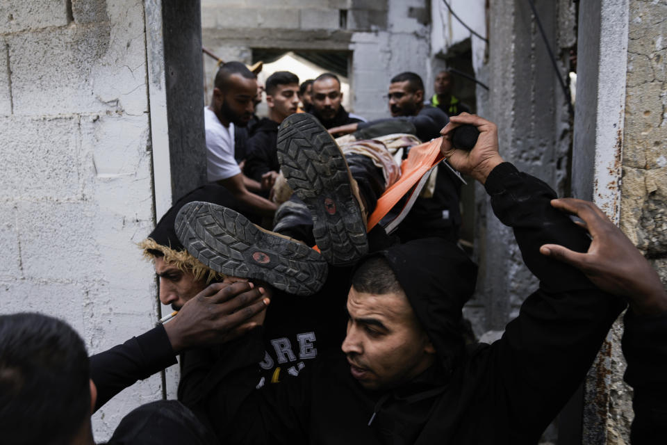 Palestinians carry a body away from the site of an Israeli strike after a military raid in the town of Tulkarem, West Bank, Wednesday, Nov. 22, 2023. The Palestinian Health Ministry said the Israeli military killed six Palestinians, five of them militants, during a raid that sparked an hourslong firefight with militants in a flashpoint refugee camp in the northern city of Tulkarem. (AP Photo/Majdi Mohammed)