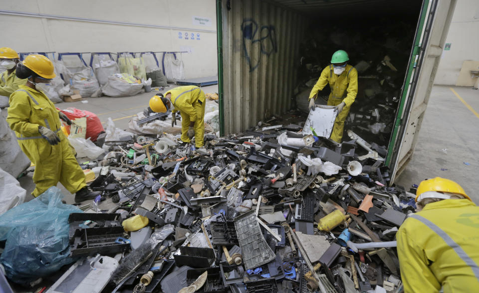 FILE - In this photo taken Monday, Aug. 18, 2014, workers unload and sort through a container full of electronic waste that was collected from a Nairobi slum and brought in for recycling, at the East African Compliant Recycling facility in Machakos, near Nairobi, in Kenya. U.N. agencies warn that electrical waste — everything from discarded refrigerators to TVs to e-scooters to mobile phones — is piling up worldwide, and recycling rates are low and likely to fall even further. (AP Photo/Ben Curtis, File)