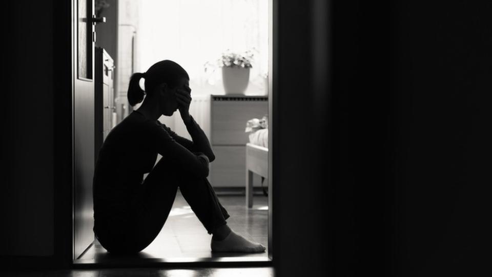 Mujer sentada en el suelo blanco y negro.