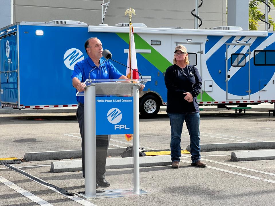 Manny Miranda, Florida Power & Light executive vice president for power delivery, left, talks about his experience working for the utility during Hurricane Andrew in 1992 as lineworker Heidi Killebrew looks on.