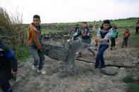 <p>Children carry a part of a missile in Quneitra, Syria, Feb. 10, 2018. (Photo: Alaa al Faqir/Reuters) </p>