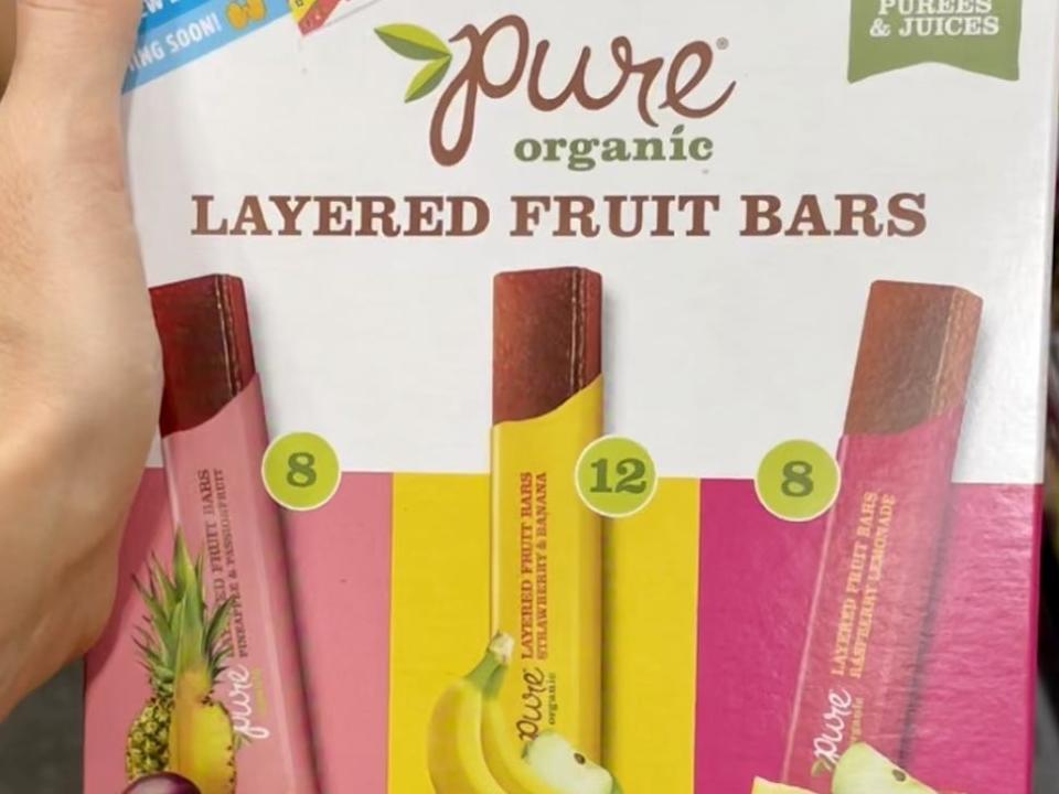 hand holding box of layered fruit bars at costco