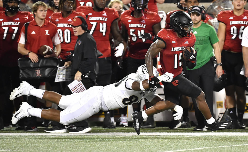 Central Florida defensive lineman Josh Celiscar (88) attempts to bring down Louisville running back Jalen Mitchell (15) during the first half of an NCAA college football game in Louisville, Ky., Friday, Sept. 17, 2021. (AP Photo/Timothy D. Easley)