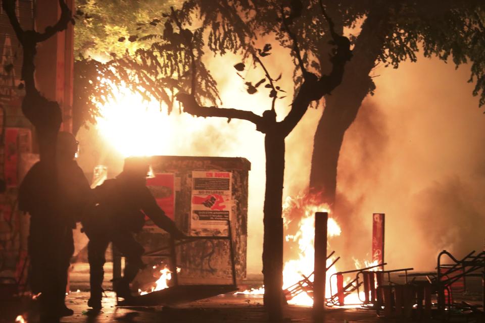 Riot policemen try to avoid petrol bombs thrown by hooded youths during clashes in the Athens neighborhood of Exarchia, a haven for extreme leftists and anarchists, Saturday, Nov. 17, 2018. Clashes have broken out between police and anarchists in central Athens on the 45th anniversary of a student uprising against Greece's then-ruling military regime. (AP Photo/Yorgos Karahalis)