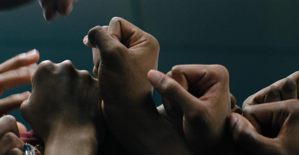 The hands of the players on the River Rouge basketball team are seen raised together in image from the film "Rouge,” a coming-of-age basketball story set in a metro Detroit community with a rich basketball tradition and some present-day struggles. The film will make its Michigan premiere on opening night at the 11th annual Freep Film Festival.