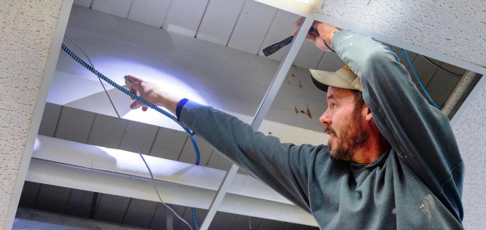 A maintenance worker at Valley View Elementary points out a crack in a classroom support beam.