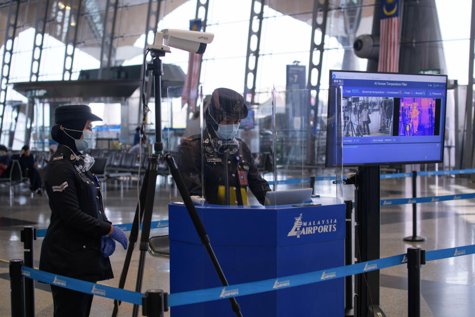 Members of the auxiliary police monitor temperatures at the main entrance of the departure hall amid concerns over the spread of the COVID-19 coronavirus at Kuala Lumpur International Airport in Sepang on September 7, 2020. (Photo by Mohd RASFAN / AFP) / The erroneous mention[s] appearing in the metadata of this photo by Mohd RASFAN has been modified in AFP systems in the following manner: [IPTC dateline: Sepang, Malaysia] instead of [IPTC dateline: Sepang, Indonesia]. Please immediately remove the erroneous mention[s] from all your online services and delete it (them) from your servers. If you have been authorized by AFP to distribute it (them) to third parties, please ensure that the same actions are carried out by them. Failure to promptly comply with these instructions will entail liability on your part for any continued or post notification usage. Therefore we thank you very much for all your attention and prompt action. We are sorry for the inconvenience this notification may cause and remain at your disposal for any further information you may require. (Photo by MOHD RASFAN/AFP via Getty Images)