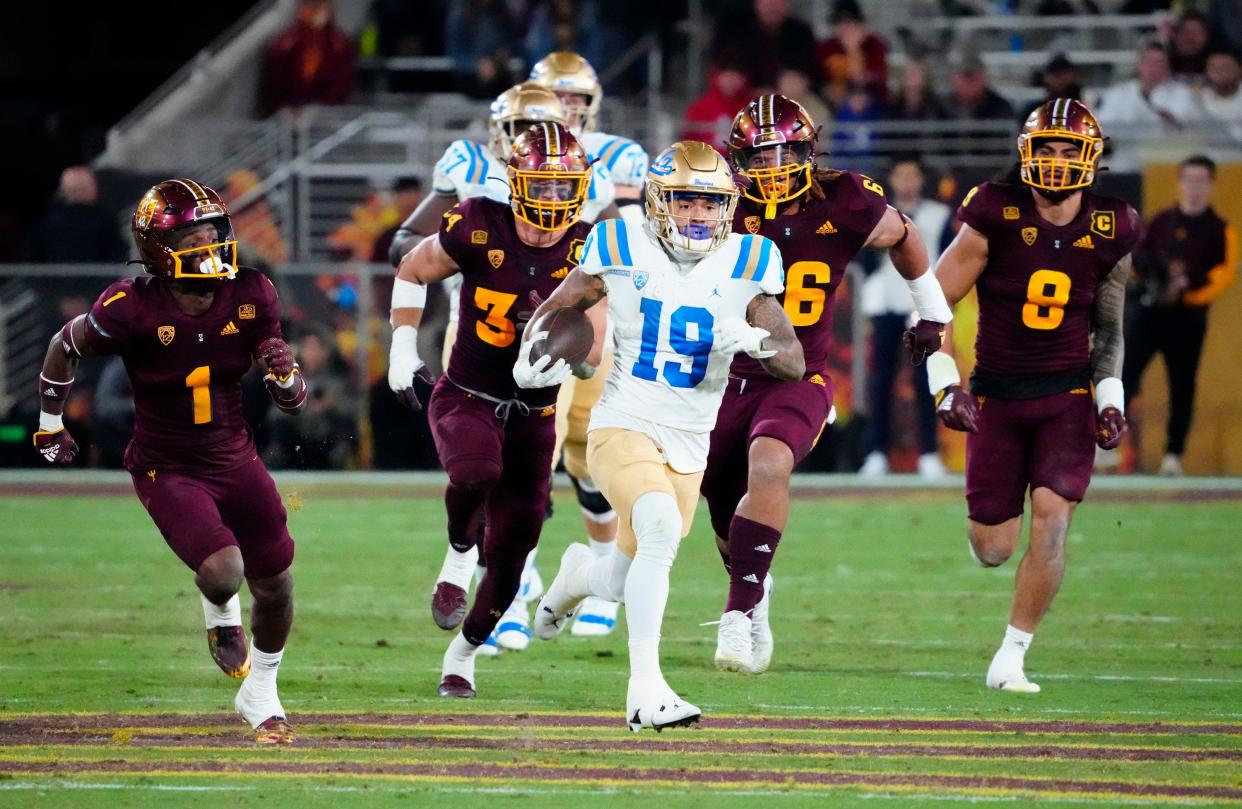 Nov 5, 2022; Tempe, AZ, USA; UCLA Bruins wide receiver Kazmeir Allen (19) runs for a touchdown past Arizona State Sun Devils defensive back Jordan Clark (1) in the second half at Sun Devil Stadium.