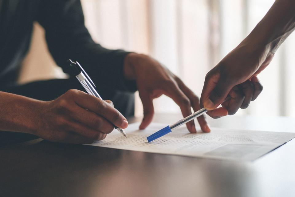 Two people signing a contract.