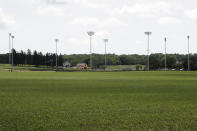 Light stands from a baseball field being built near the Field of Dreams movie site, rear, are seen, Friday, June 5, 2020, in Dyersville, Iowa. Major League Baseball is building the field a few hundred yards down a corn-lined path from the famous movie site in eastern Iowa but unlike the original, it's unclear whether teams will show up for a game this time as the league and its players struggle to agree on plans for a coronavirus-shortened season. (AP Photo/Charlie Neibergall)