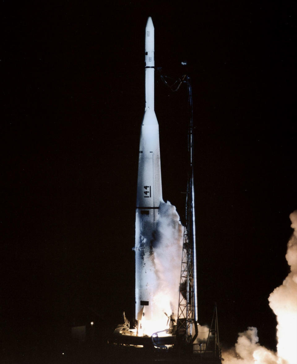 a white rocket launches into a black night sky