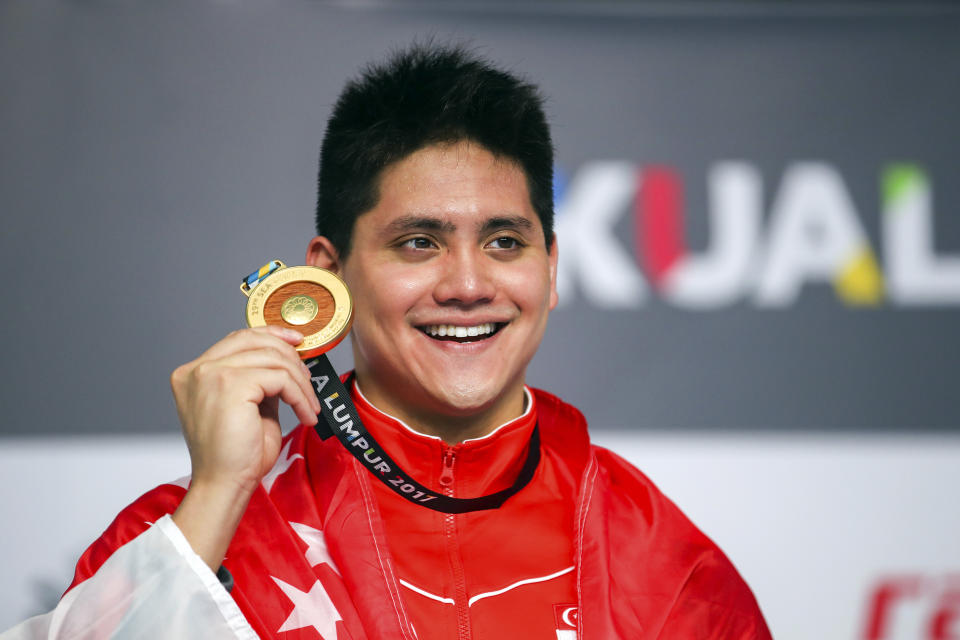 Singapore's Joseph Schooling smiles with his medal after winning the Men's 50M Butterfly Swimming final of the 29th South East Asian Games in Kuala Lumpur, Malaysia, Monday, Aug. 21, 2017. (AP Photo/Adrian Hoe)