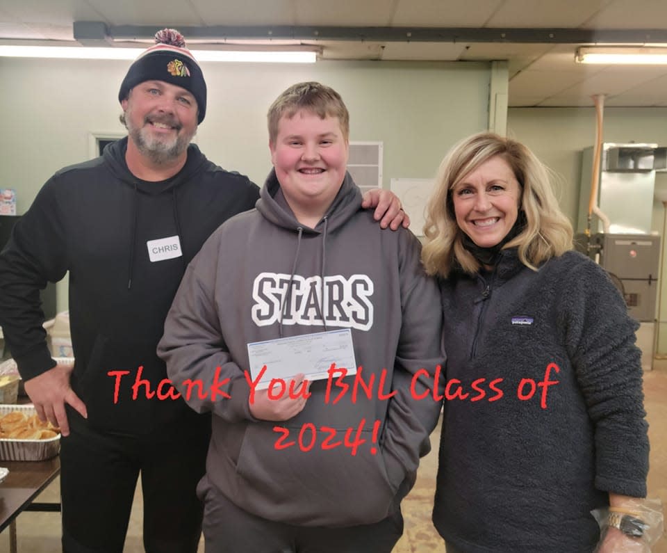 Carson Boady, his teacher Tiffany Kurtz and her husband Chris Kurtz present a donation of $500 to the Men's Warming Shelter.