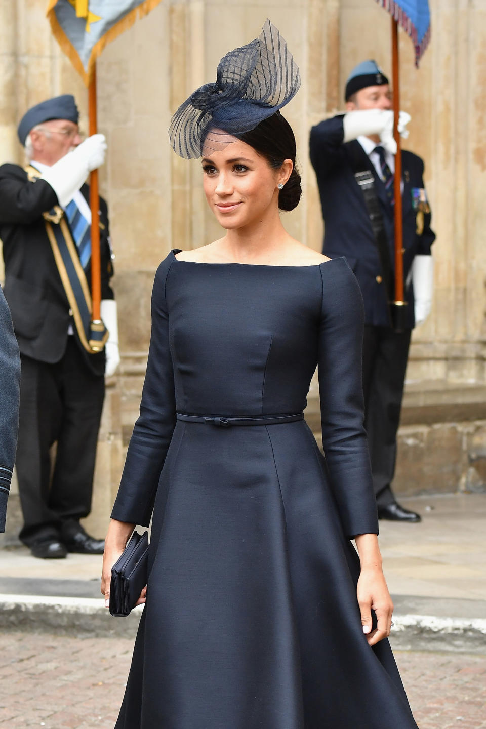 <p>On July 10, the Duchess of Sussex wore a navy Dior dress with a bateau neckline and a coordinating fascinator for the Royal Air Force’s centenary celebrations. To finish the regal aesthetic, she opted for a smart low bun. (Photo: Getty Images) </p>