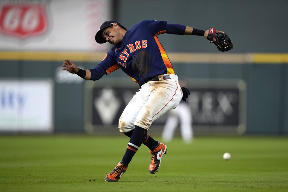 Houston Astros second baseman Mauricio Dubon tries to handle a fielding error by first baseman Jose Abreu on a ball hit by Texas Rangers' Nathaniel Lowe during the eighth inning of a baseball game Sunday, April 16, 2023, in Houston. (AP Photo/David J. Phillip)