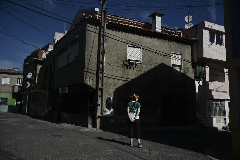 A tourist stands on a street corner in the Cova da Moura neighborhood of Amadora, on the outskirts of Lisbon, on October 23, 2014