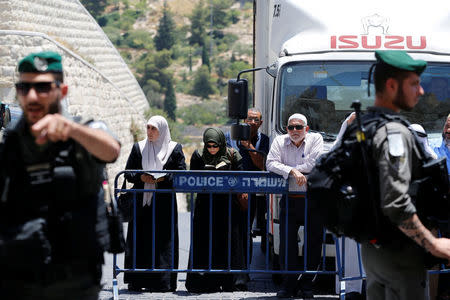 Palestinians stand next to a police barricade as they wait for the compound known to Muslims as Noble Sanctuary and to Jews as Temple Mount to be reopened, in Jerusalem's Old City July 16, 2017. REUTERS/Ammar Awad