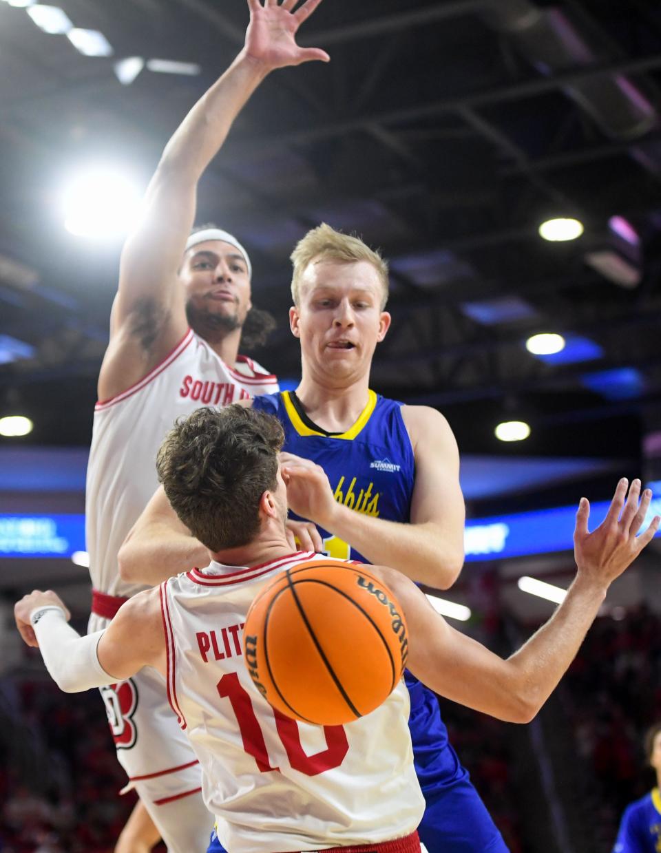 South Dakota’s Damani Hayes and A.J. Plitzuweit collide with South Dakota State’s Matthew Mors near the basket in a rivalry matchup on Saturday, January 14, 2023, at the Sanford Coyote Sports Center in Vermillion.