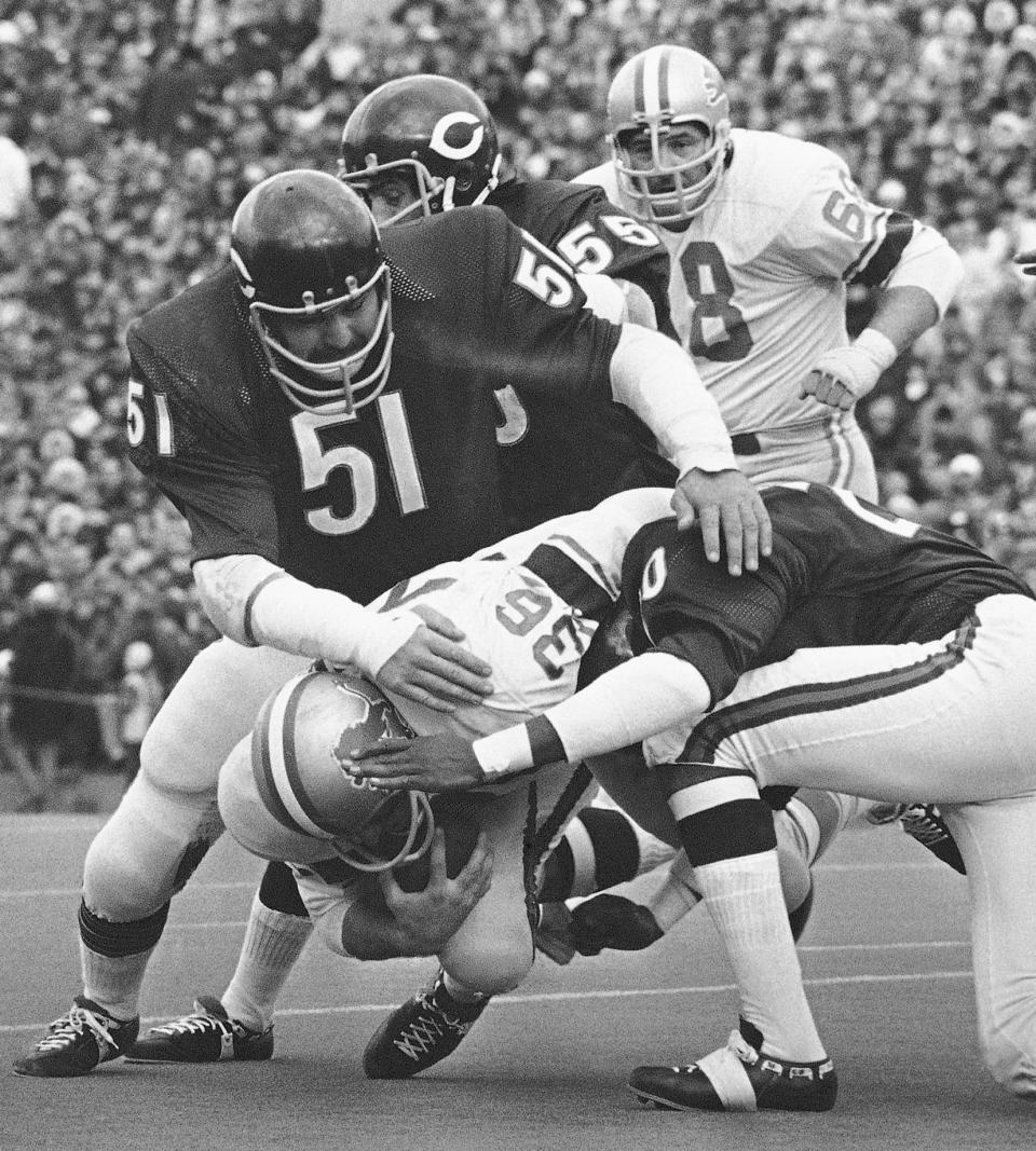 FILE - Chicago Bears' Dick Butkus (51), Doug Buffone (55) and Joe Taylor (20) stop Detroit Lions running back Steve Owens (36) during an NFL football game Nov. 21, 1971, in Chicago. Butkus, a fearsome middle linebacker for the Bears, has died, the team announced Thursday, Oct. 5, 2023. He was 80. According to a statement released by the team, Butkus' family confirmed that he died in his sleep overnight at his home in Malibu, Calif. (AP Photo/Fred Jewell)